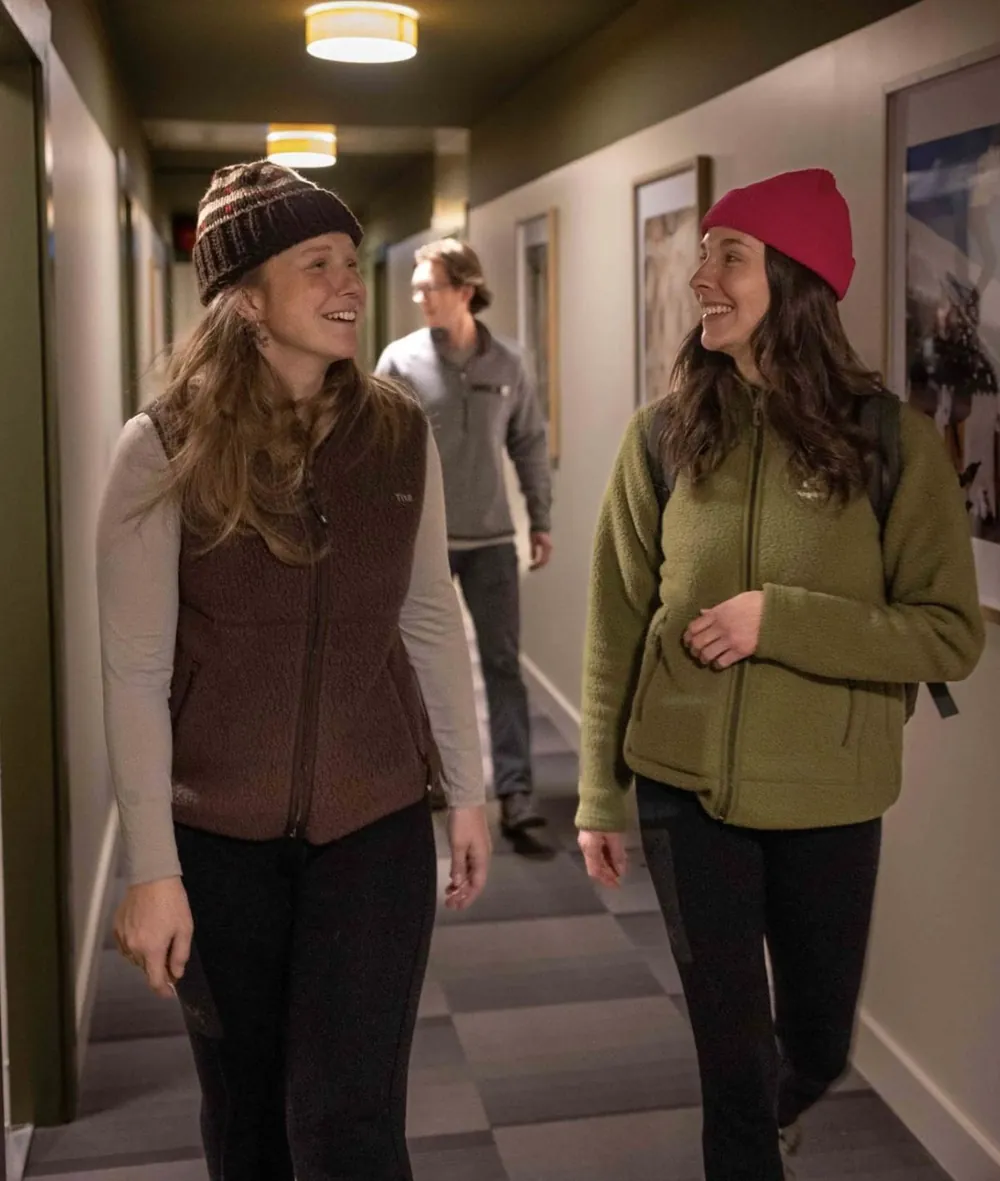 Three guests walking and laughing in the hostel hallway