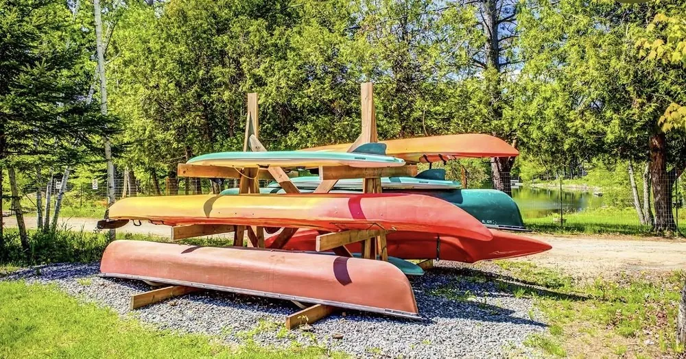 Canoes, kayaks and paddleboards on a rack by Lac Moore